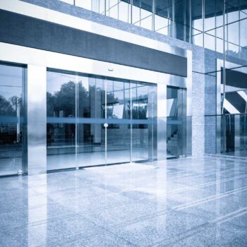 modern office building gate entrance and automatic glass door with blue tone