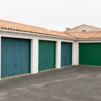 Row of green parking garage doors in parking area for apartment and home suburb