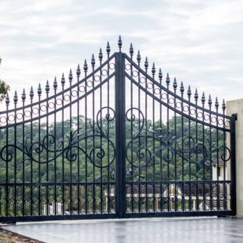 Black metal wrought iron driveway property entrance gates set in