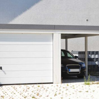 Moderne Beton-Garage mit Automatik-Tor und angebautem Carport in