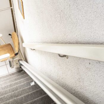 Automatic stair lift on staircase taking elderly people and disabled persons up and down in a house close-up