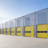 exterior of a commercial warehouse with yellow roller doors