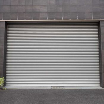 A closeup shot of automatic metal roller door used in factory, storage, garage, and industrial warehouse. The corrugated and foldable metal sheet offer space saving and provide urban and rustic feel